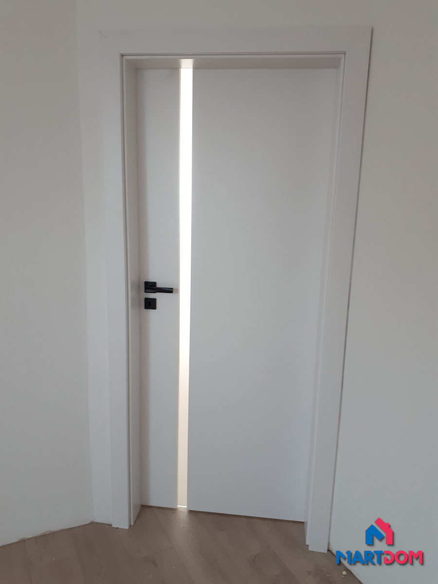 Drzwi z pionową szybą matową Porta Focus kolor biały czarna klamka zamek na klucz drzwi pokojowe ściany białe jasna podłoga montaż martdom kraków okolice