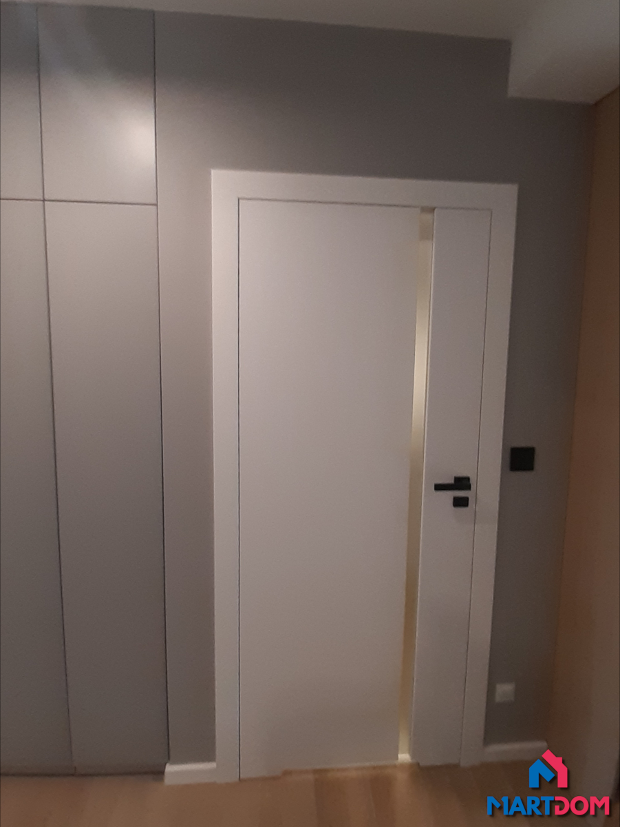 Szyba pionowa matowa drzwi białe porta klamka kwadratowa czarna szare ściany białe listwy jasne panele