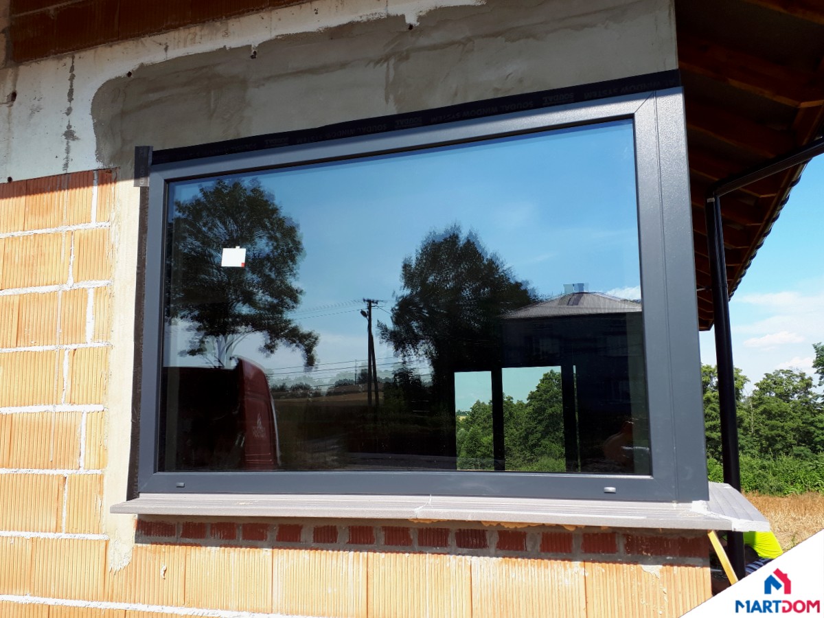 Produkt: Okna PCV, w tym okno narożne otwierane ze słupkiem Producent: AdamS Profil: Veka SL 82 Kolor: Obustronny kolor antracyt piaskowy Dodatki: Klamka antracyt, taśmy Soudal, parapety ciepłe, termiczne podwaliny