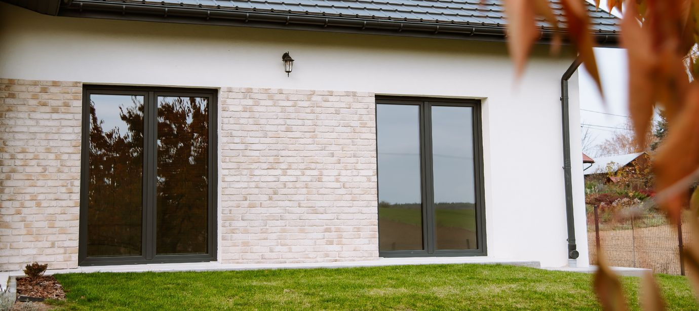 dwa okna balkonowe w domu parterowym w kolorze antracyt do artykułu o oknach balkonowych czym są jak się je montuje ile kosztują jakie są rodzaje